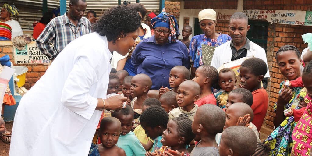 Dr. Marie Claire Manafundu, who coordinates the church’s Maternal and Child Health Program in eastern Congo, talks with children outside of United Methodist Irambo Health Center in Bukavu, Congo. The United Methodist Church in East Congo offers food support to families affected by HIV and AIDS. (Photo: Philippe Kituka Lolonga, UM News)