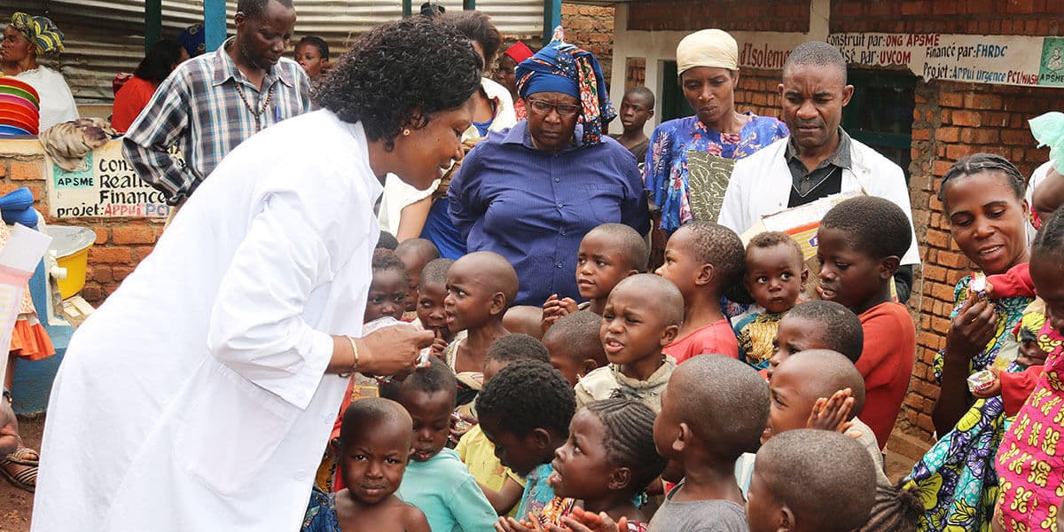 Dr. Marie Claire Manafundu, who coordinates the church’s Maternal and Child Health Program in eastern Congo, talks with children outside of United Methodist Irambo Health Center in Bukavu, Congo. The United Methodist Church in East Congo offers food support to families affected by HIV and AIDS. (Photo: Philippe Kituka Lolonga, UM News)