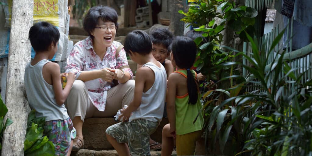 The Rev. Grace Choi served as a community health worker in the outreach programs of Harris Memorial College in the Philippines. Here she visits with children in the Upper Javier neighborhood of the town of Taytay. (Photo: Paul Jeffrey, 2012)